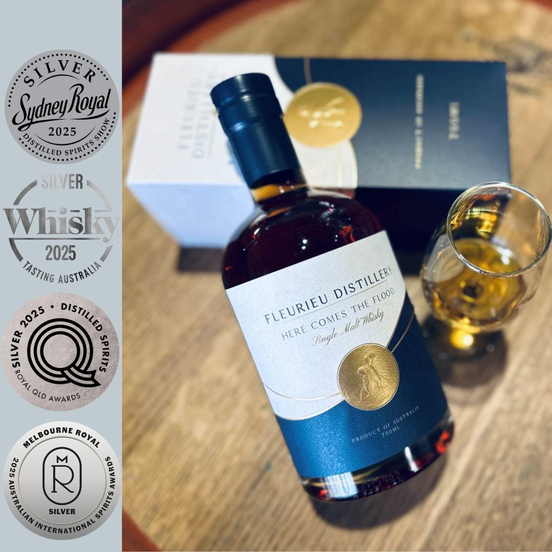 Fleurieu Distillery whisky bottle with a glass and four silver medals on a wooden surface